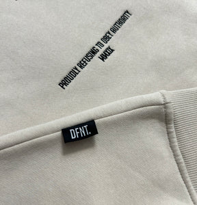 A close up of the amazing design on the Oversized DFNT. Eternity Hoodies.  This close up shows the precision embroidery in black on an off-white garment.  it also shows the subtle DFNT. tag that is sewn into the seem for that extra touch of class and branding. 