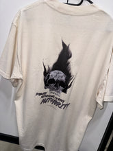 Load image into Gallery viewer, A photo showing the back of a unisex t-shirt.  The shirt has a big bold print on the back of a skull in flames. Underneath the skull is the defiant tag line &#39;Proudly Refusing To Obey Authority&#39; with the The Defiant Co logo under that. The t-shirt is ecru in colour.