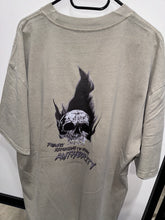 Load image into Gallery viewer, A photo showing the back of a unisex t-shirt.  The shirt has a big bold print on the back of a skull in flames. Underneath the skull is the defiant tag line &#39;Proudly Refusing To Obey Authority&#39; with the The Defiant Co logo under that. The t-shirt is faded eucalyptus in colour.
