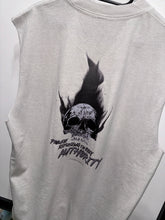 Load image into Gallery viewer, A photo showing the back of a unisex sleeveless t-shirt.  The shirt has a big bold print on the back of a skull in flames. Underneath the skull is the defiant tag line &#39;Proudly Refusing To Obey Authority&#39; with the The Defiant Co logo under that. The sleeveless is faded bone in colour.