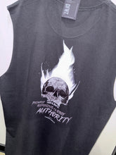 Load image into Gallery viewer, A photo showing the back of a unisex sleeveless t-shirt.  The shirt has a big bold print on the back of a skull in flames. Underneath the skull is the defiant tag line &#39;Proudly Refusing To Obey Authority&#39; with the The Defiant Co logo under that. The sleeveless is faded coal in colour.