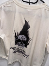 Load image into Gallery viewer, A photo showing the back of a female fit cropped t-shirt.  The shirt has a big bold print on the back of a skull in flames. Underneath the slull is the defiant tag line &#39;Proudly Refusing To Obey Authority&#39; with the The Defiant Co logo under that. The shirt is ecru in colour.