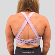 Load image into Gallery viewer, A photo showing the back of the amazing The Defiant Co Infinity Sports Bra.  The bra has a unique crossed back with The Defiant Co logo across both straps giving it a really standout look. The colour is lilac.