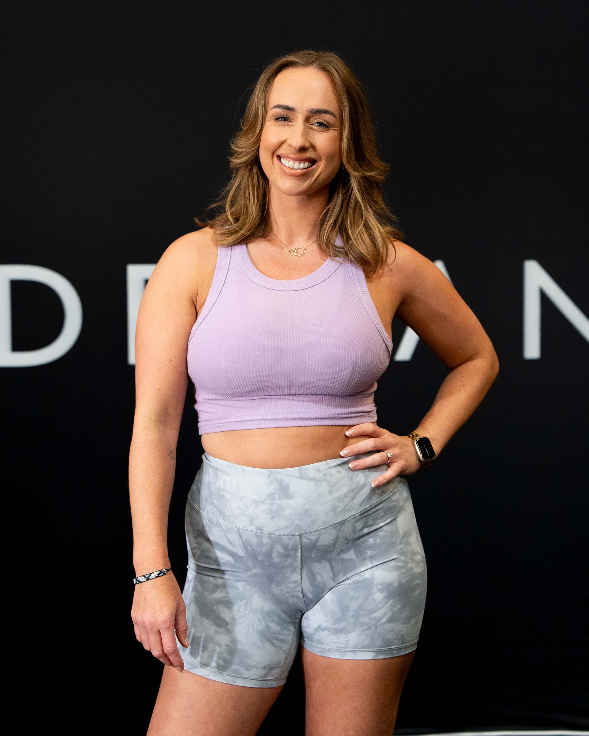 A girl against a black The Defiant Co backdrop wearing the DFNT. Ribbed Cropped Tank.  The tank is breathable with a stretchy fabric so is perfect for working out in.  It has a subtle DFNT. logo on a tag.  The colour is lilac.