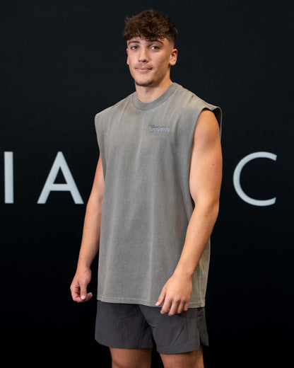 A guy against a black The Defiant Co backdrop wearing the faded grey proudly refusing to obey authority sleeveless tee and charcoal performance shorts. 