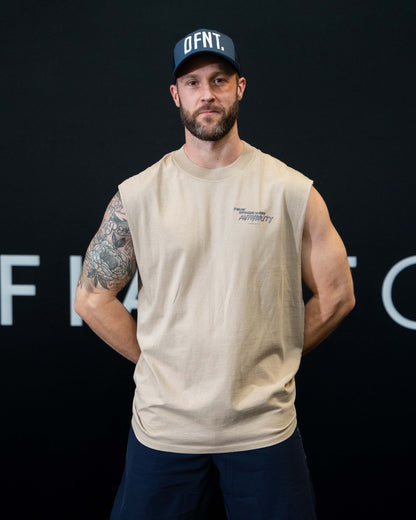 A guy against a black The Defiant Co backdrop wearing the faded bone proudly refusing to obey authority sleeveless tee and navy performance shorts.