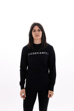Load image into Gallery viewer, A photo showing ‘The Defiant Co’ long sleeved unisex t-shirt. The shirt has the famous ‘The Defiant Co’ logo across the front of the chest.  The shirt has a round neck and is slightly oversized. The shirt colour is black.