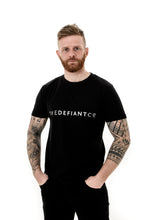 Load image into Gallery viewer, A guy with visible tattoos wearing The Defiant Co short sleeved t-shirt.  The t-shirt is 100% cotton and is extremely high quality making it a staple for the gym and beyond.  The famous The Defiant Co logo is embossed across the centre of the chest and the colour of the tee is black.