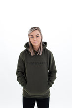Load image into Gallery viewer, A girl wearing a standard fit, unisex The Defiant Co Hoodie.  The hoodie has draw strings and a pouch pocket on the front as per all standard designs.  The hoodie has the famous The Defiant Co logo across the front of the chest and is plain on the back.  The colour is olive green.