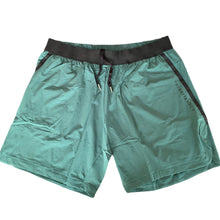 Load image into Gallery viewer, A photo of the best selling The Defiant Co Performance Shorts.  The shorts have a black elasticated waistband with draw strings and have The Defiant Co logo down the left leg.  The shorts have two pockets, one either side and are the colour racing green.