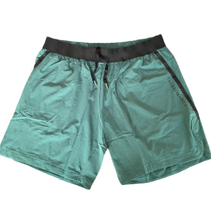 A photo of the best selling The Defiant Co Performance Shorts.  The shorts have a black elasticated waistband with draw strings and have The Defiant Co logo down the left leg.  The shorts have two pockets, one either side and are the colour racing green.