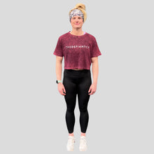 Load image into Gallery viewer, A photo showing a female fit, slightly oversized, cropped acid wash t-shirt. The shirt has the famous ‘The Defiant Co’ logo across the front of the chest.  The acid Wash effect of the shirt means no two are alike and provides the perfect blend of fashion and defiance. The shirt is burgundy in colour with a slightly black wash.
