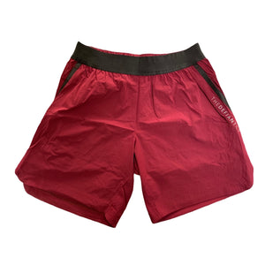 A photo of the best selling The Defiant Co Performance Shorts.  The shorts have a black elasticated waistband with draw strings and have The Defiant Co logo down the left leg.  The shorts have two pockets, one either side and are the colour burgundy.