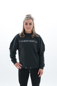 A photo showing The Defiant Co women's oversized crewneck. The crewneck has a roundneck and draw string around the bottom. The crews have the famous The Defiant Co logo across the front of the chest and are plain on the back. The colour is charcoal grey.